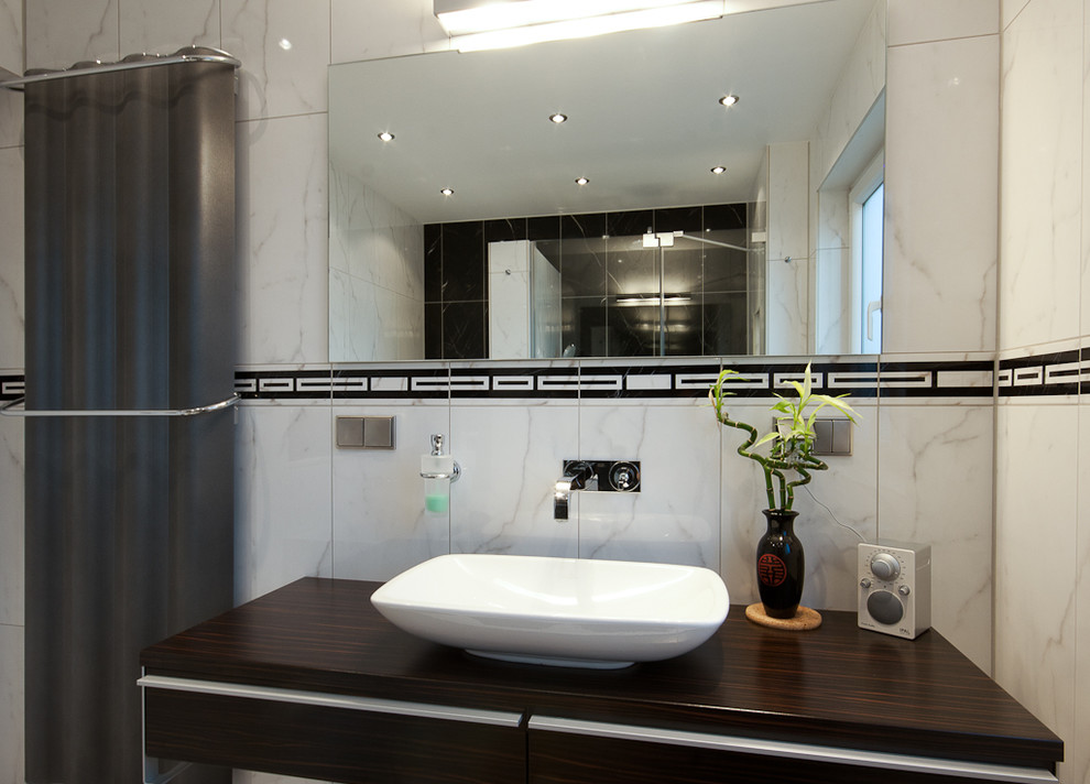 Badezimmer En Suite With flächenbündigen Schrankfronten, braunen Schränken, Einbaubadewanne, bodengleicher Dusche, farbigen Fliesen, Keramikfliesen, bunten Wänden, Keramikboden, Aufsatzwaschbecken, Waschtisch aus Holz and buntem Boden in Frankfurt