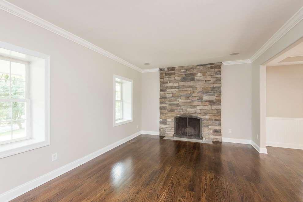 Large transitional formal open concept living room in Philadelphia with grey walls, medium hardwood floors, a standard fireplace, a stone fireplace surround, no tv and brown floor.