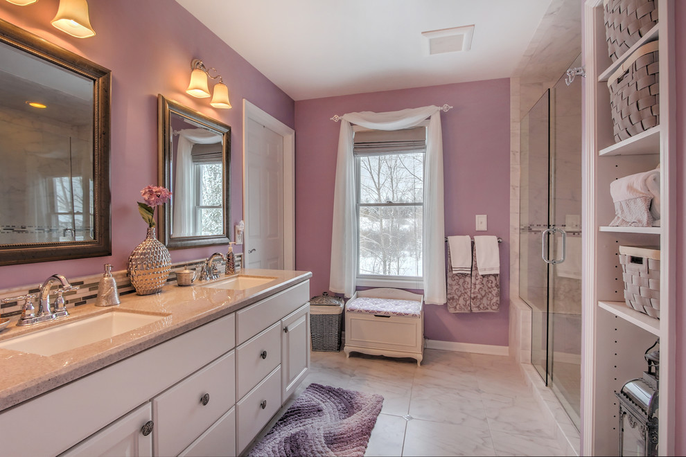 Design ideas for a mid-sized traditional bathroom in Grand Rapids with an undermount sink, white cabinets, an alcove shower, white tile, ceramic tile, marble floors, raised-panel cabinets, purple walls and solid surface benchtops.