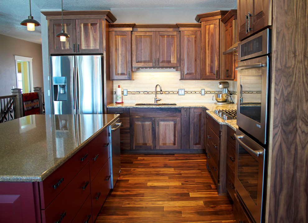 Example of a mid-sized transitional l-shaped medium tone wood floor kitchen pantry design with an undermount sink, raised-panel cabinets, dark wood cabinets, quartz countertops, beige backsplash, stone tile backsplash, stainless steel appliances and an island