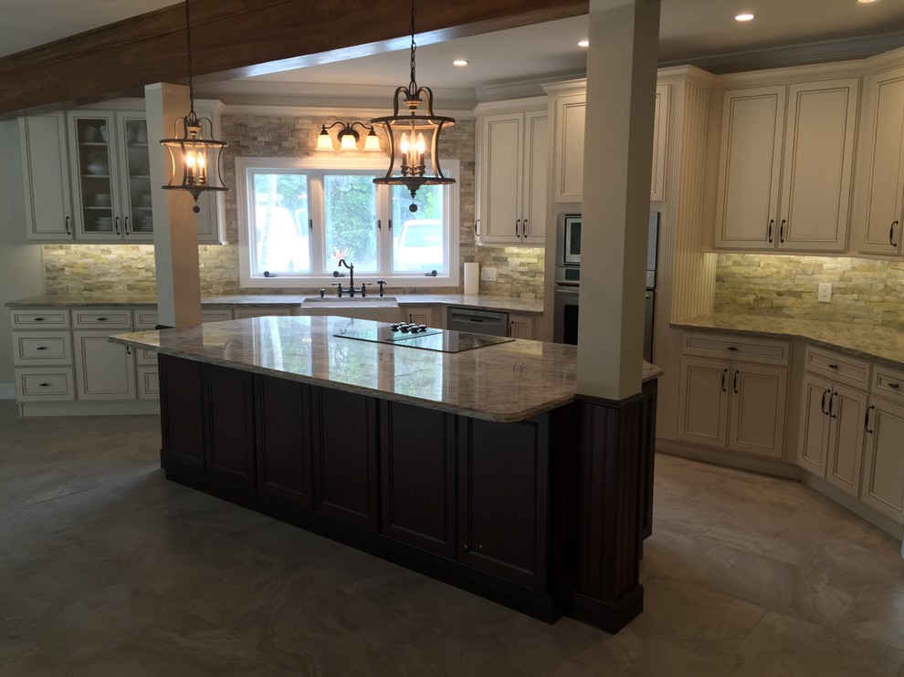 Example of a large transitional kitchen design in Miami with a farmhouse sink, recessed-panel cabinets, granite countertops, stone tile backsplash and an island