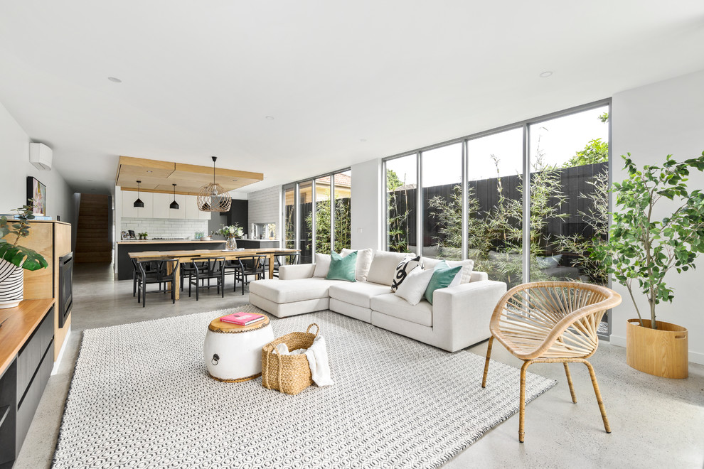 Scandinavian open concept living room in Melbourne with white walls and concrete floors.