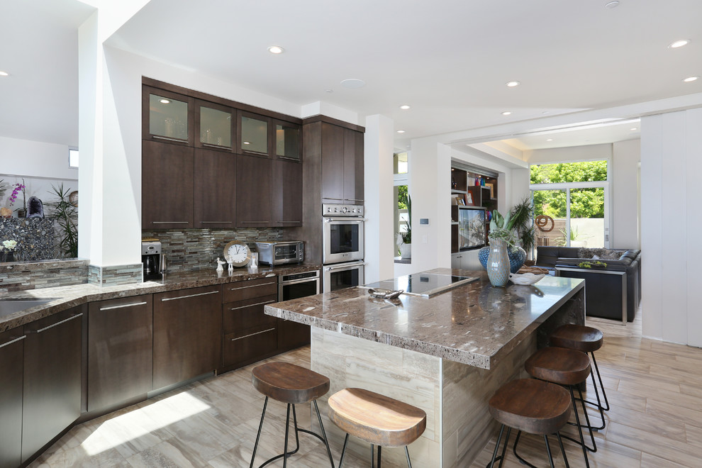 Photo of a transitional single-wall open plan kitchen in Orange County with an undermount sink, flat-panel cabinets, dark wood cabinets, quartzite benchtops, multi-coloured splashback, glass tile splashback, stainless steel appliances, ceramic floors and with island.