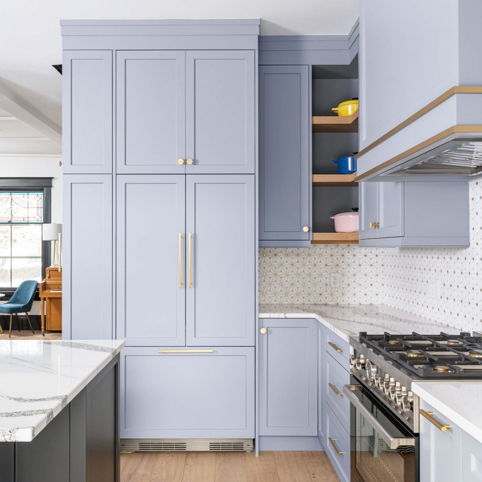 Inspiration for a transitional l-shaped kitchen in Toronto with a farmhouse sink, shaker cabinets, blue cabinets, quartz benchtops, multi-coloured splashback, light hardwood floors, with island and multi-coloured benchtop.