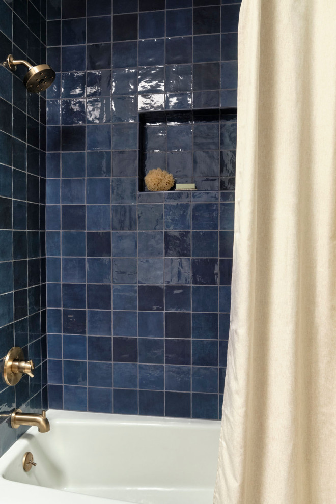 Idée de décoration pour une salle de bain tradition en bois clair de taille moyenne avec un placard à porte shaker, une baignoire en alcôve, un combiné douche/baignoire, WC séparés, un carrelage bleu, des carreaux de céramique, un mur blanc, tomettes au sol, un lavabo encastré, un plan de toilette en quartz modifié, une cabine de douche avec un rideau, un plan de toilette blanc, une niche, meuble simple vasque et meuble-lavabo encastré.
