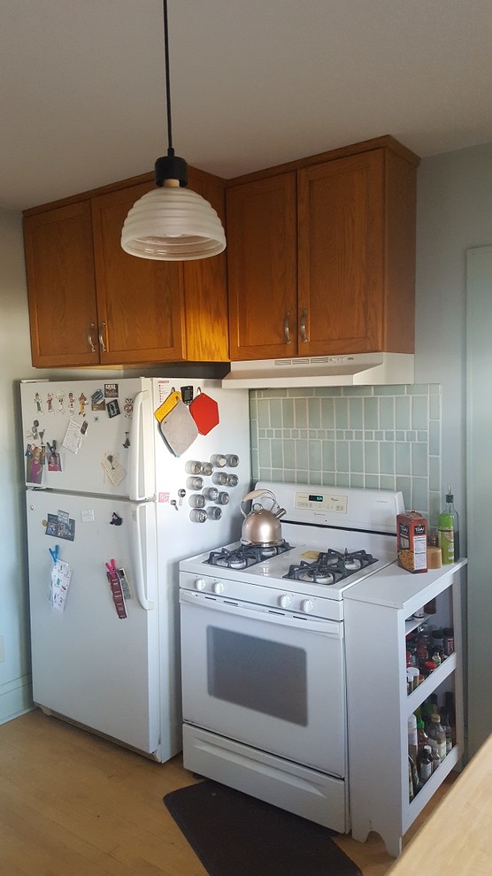 Example of a small light wood floor enclosed kitchen design with a double-bowl sink, flat-panel cabinets, wood countertops, gray backsplash, ceramic backsplash, white appliances and no island
