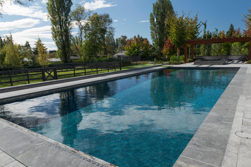 Idées déco pour une très grande piscine arrière craftsman rectangle avec des pavés en pierre naturelle.