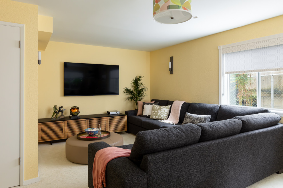 Ejemplo de cine en casa abierto y blanco ecléctico de tamaño medio con paredes amarillas, moqueta, televisor colgado en la pared y suelo blanco