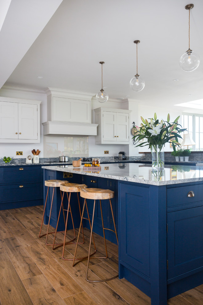 Inspiration for a mid-sized transitional l-shaped kitchen in Kent with beaded inset cabinets, blue cabinets, granite benchtops, glass sheet splashback, with island and medium hardwood floors.