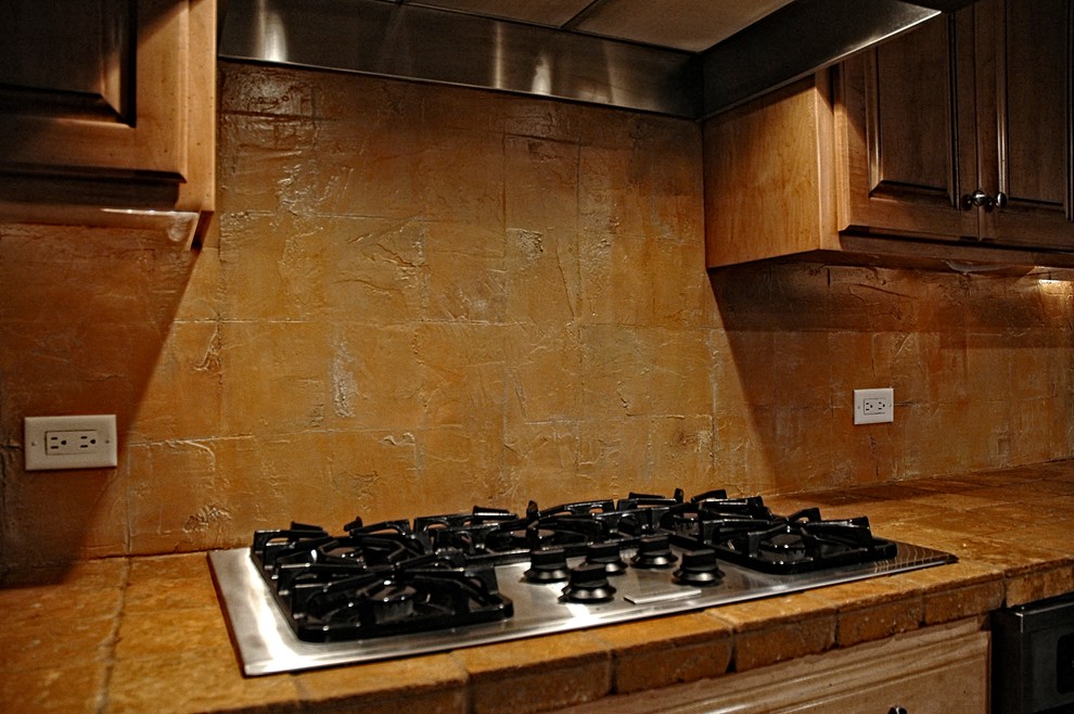 Kitchen pantry - large traditional single-wall kitchen pantry idea in Phoenix with raised-panel cabinets, medium tone wood cabinets, tile countertops, multicolored backsplash and stainless steel appliances