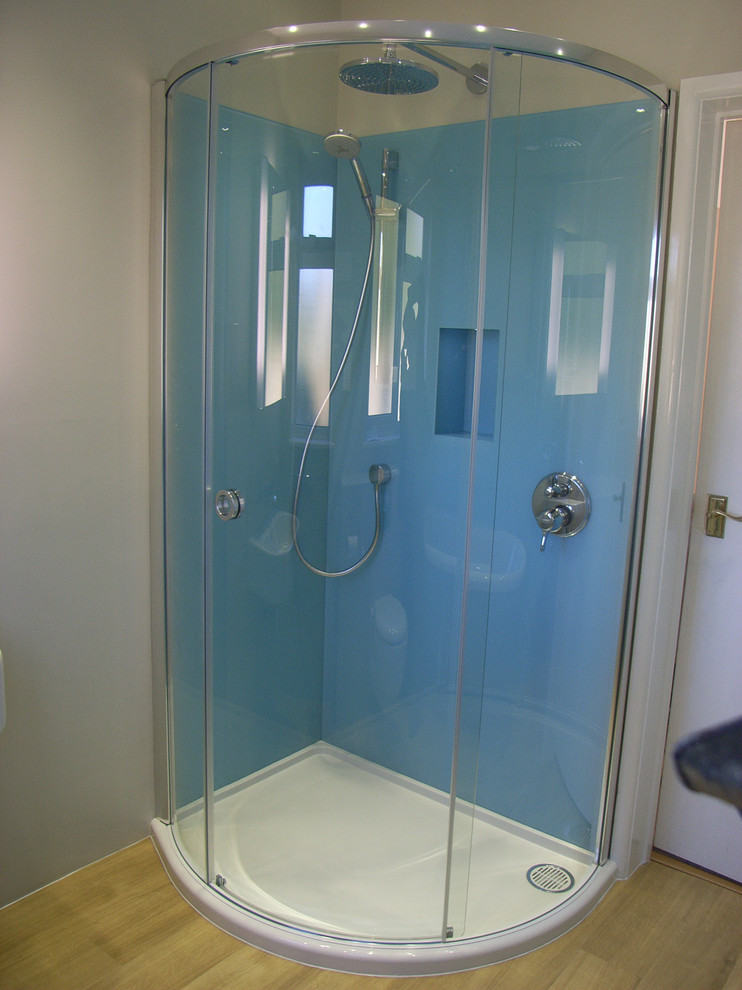 This is an example of a small contemporary kids bathroom in Other with a corner shower, blue tile, glass sheet wall and linoleum floors.