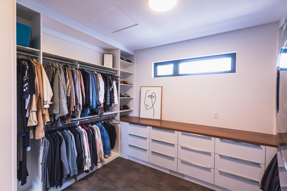 Photo of a mid-sized country walk-in wardrobe in Edmonton with flat-panel cabinets, white cabinets, linoleum floors and grey floor.