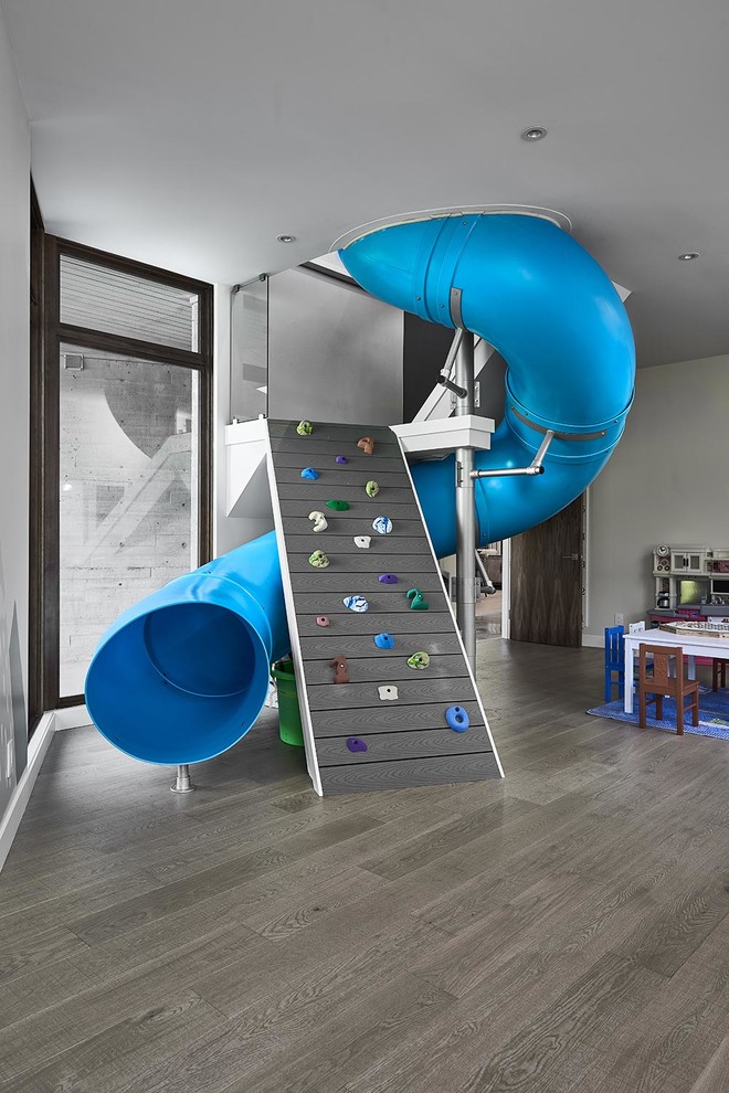Design ideas for a large contemporary gender-neutral kids' playroom for kids 4-10 years old in Other with grey walls, dark hardwood floors and grey floor.