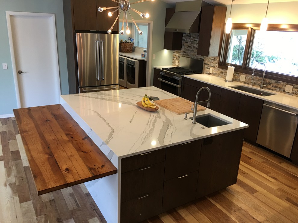 This is an example of a mid-sized contemporary u-shaped eat-in kitchen in Other with a single-bowl sink, flat-panel cabinets, dark wood cabinets, quartzite benchtops, grey splashback, stone tile splashback, stainless steel appliances, medium hardwood floors, with island and brown floor.
