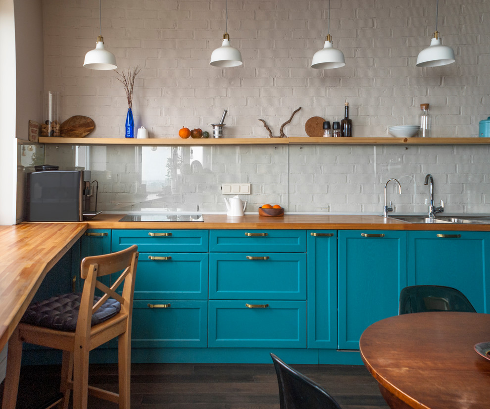 Design ideas for a transitional eat-in kitchen in Other with a double-bowl sink, shaker cabinets, turquoise cabinets, wood benchtops, white splashback, glass sheet splashback, dark hardwood floors and brown floor.