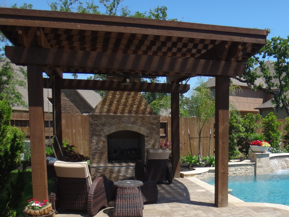 Inspiration for a large traditional backyard patio in Houston with a water feature and brick pavers.