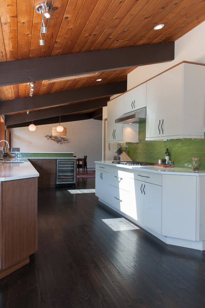 Inspiration for a midcentury kitchen in Wilmington with an undermount sink, flat-panel cabinets, quartz benchtops, green splashback, stainless steel appliances, dark hardwood floors, a peninsula, brown floor and white benchtop.