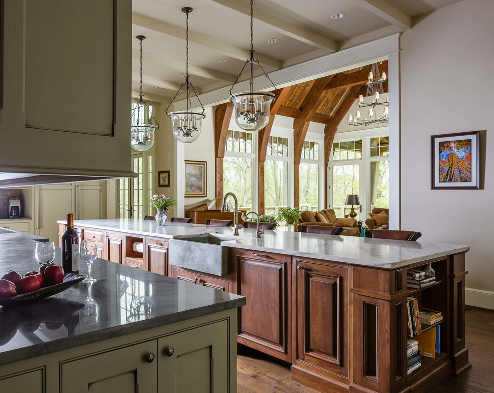 Photo of an expansive traditional l-shaped open plan kitchen in Nashville with a farmhouse sink, flat-panel cabinets, green cabinets, marble benchtops, brown splashback, panelled appliances, medium hardwood floors and with island.