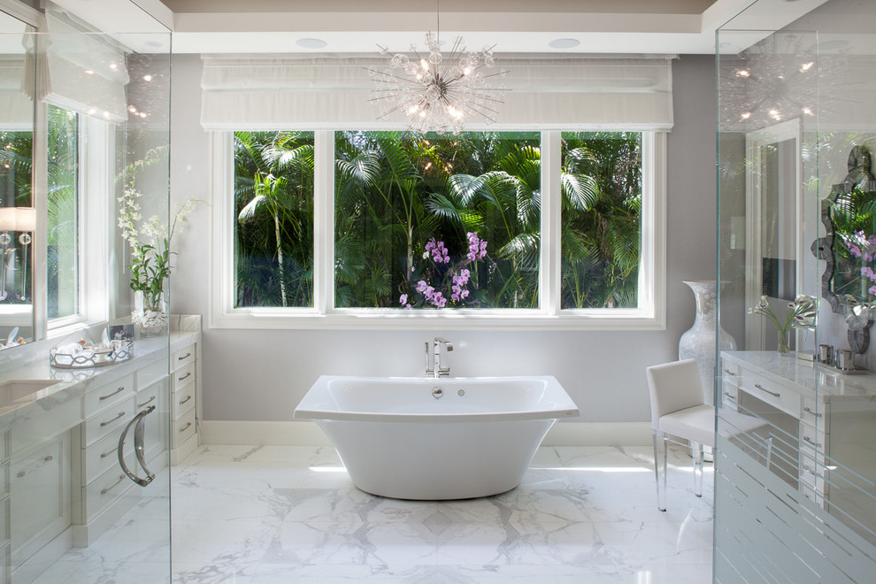 Design ideas for a mid-sized transitional master bathroom in Miami with a freestanding tub, grey walls, marble floors, an undermount sink, marble benchtops, grey floor, a hinged shower door, recessed-panel cabinets and white cabinets.
