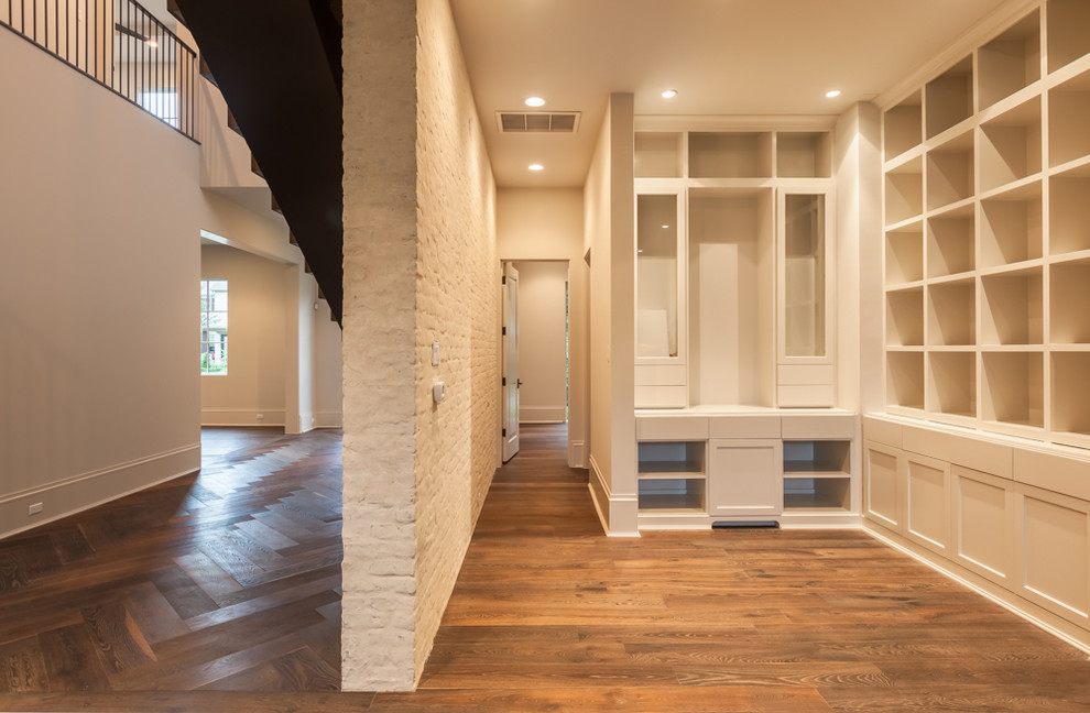 Example of a large transitional medium tone wood floor hallway design in Houston with beige walls