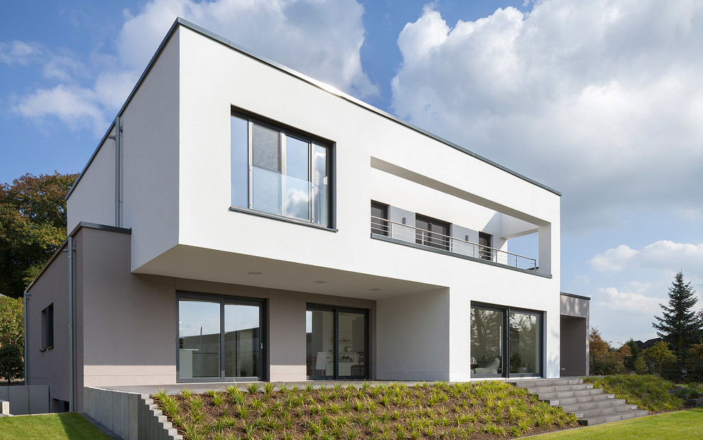 This is an example of a large modern two-storey white exterior in Cologne with a flat roof.