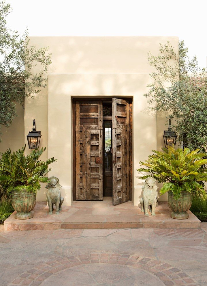 Photo of a mediterranean front door in San Diego with beige walls, a double front door and a dark wood front door.