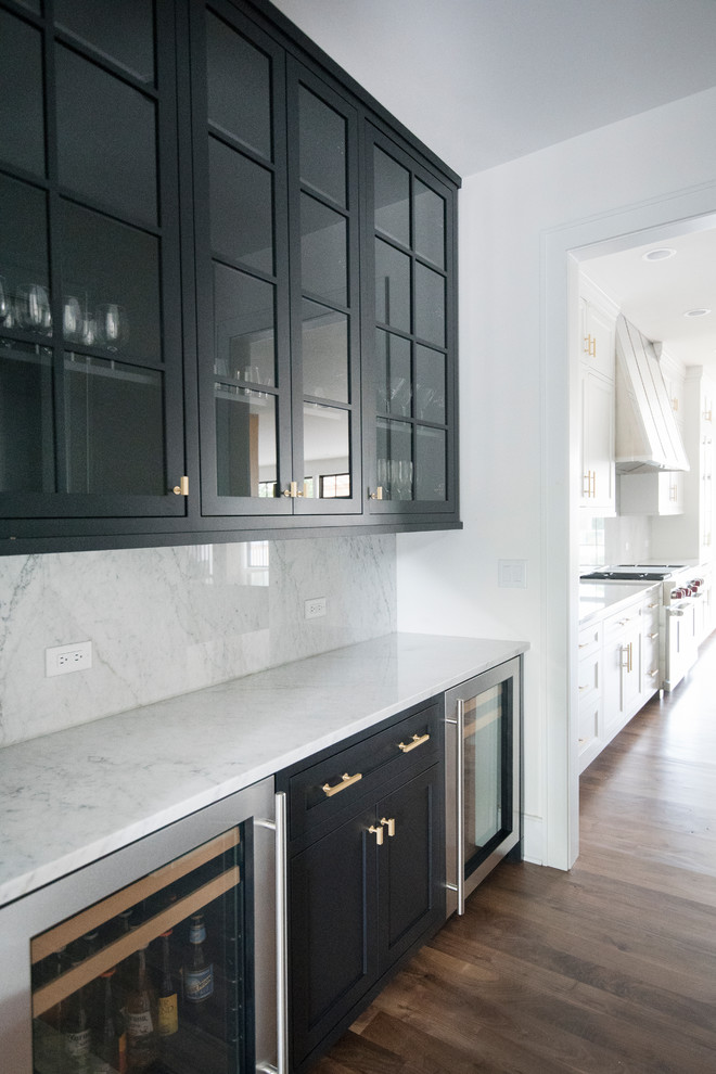 Inspiration for a large contemporary l-shaped home bar in Chicago with an undermount sink, shaker cabinets, white cabinets, grey splashback, stone slab splashback, dark hardwood floors and brown floor.