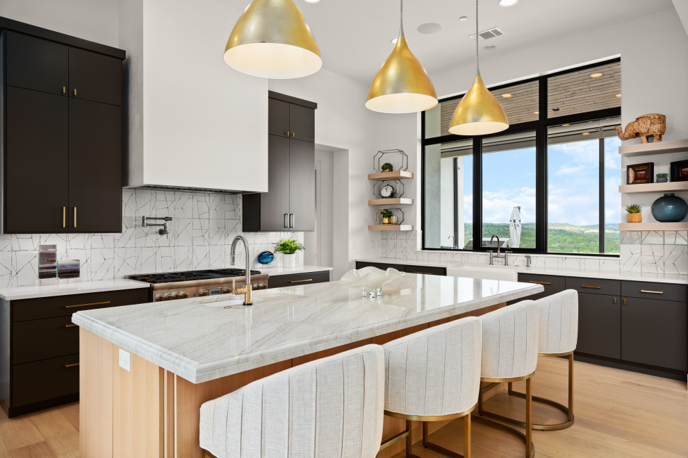 Transitional u-shaped light wood floor open concept kitchen photo in Austin with a farmhouse sink, flat-panel cabinets, quartzite countertops, white backsplash, paneled appliances and an island