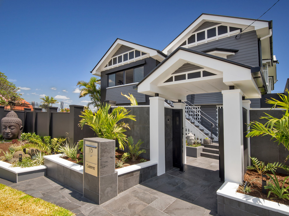 Large modern two-storey black house exterior in Brisbane with wood siding.