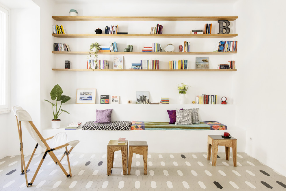 Стильный дизайн: маленькая открытая гостиная комната в стиле фьюжн с с книжными шкафами и полками, белыми стенами и разноцветным полом для на участке и в саду - последний тренд