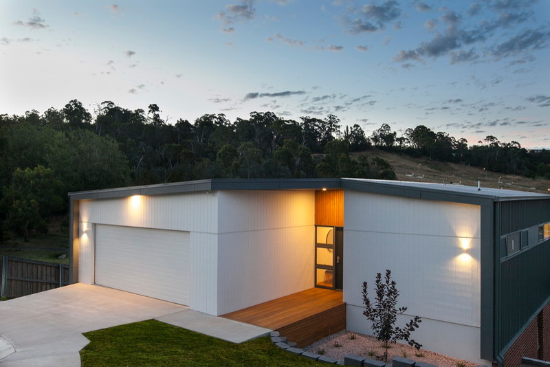 Mid-sized modern two-storey white exterior in Hobart with concrete fiberboard siding and a flat roof.