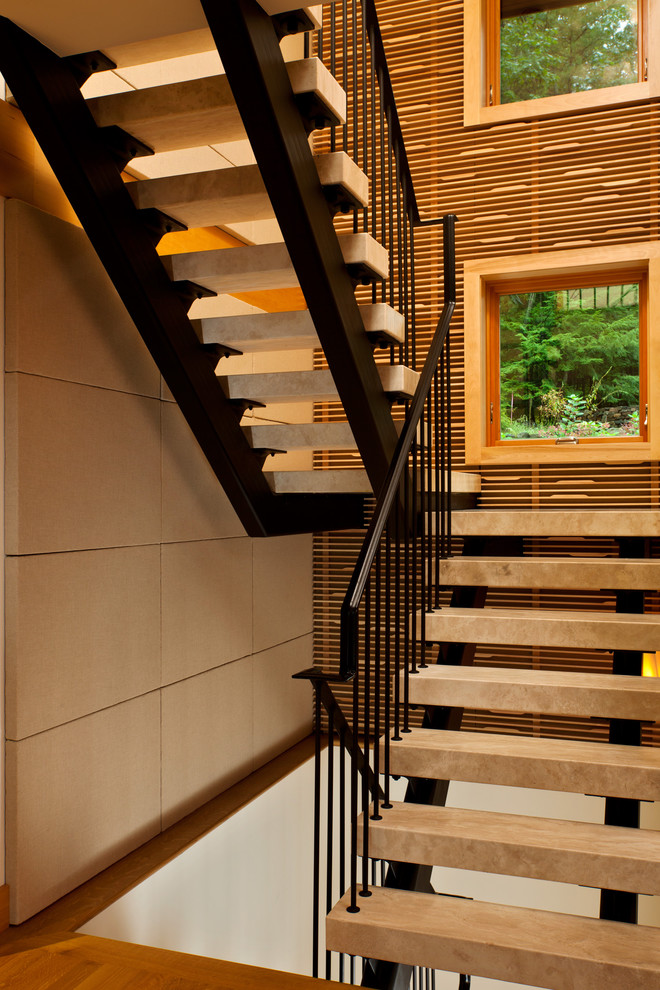 Contemporary travertine u-shaped staircase in New York with open risers and metal railing.