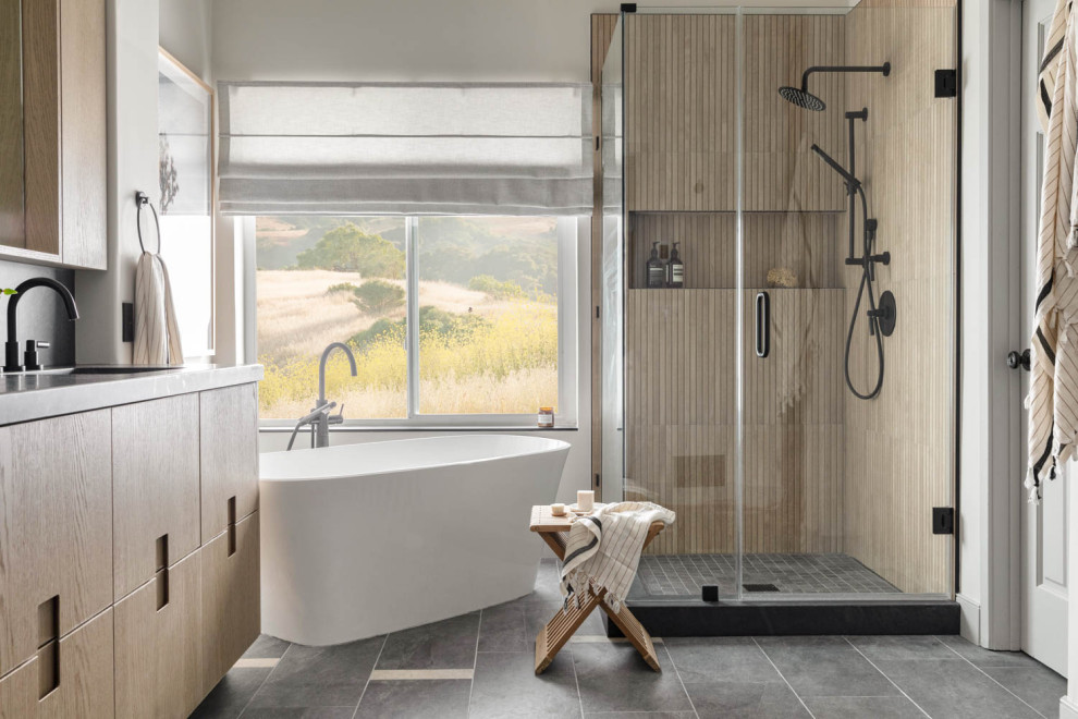 Modern inredning av ett mellanstort grå grått en-suite badrum, med ett fristående badkar, en hörndusch, släta luckor, bruna skåp, klinkergolv i keramik, ett undermonterad handfat, granitbänkskiva, grått golv och dusch med gångjärnsdörr