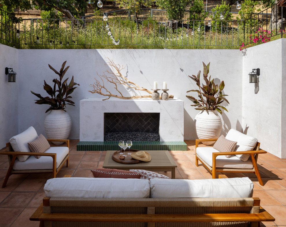 Inspiration for a large mediterranean backyard concrete paver patio remodel in San Francisco with a fireplace
