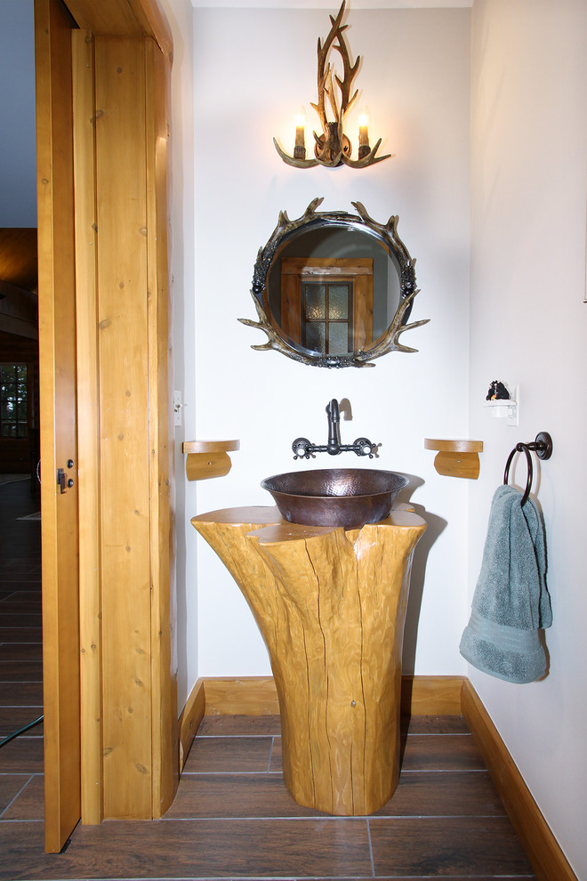 Design ideas for a mid-sized country powder room in Other with light wood cabinets, white walls, dark hardwood floors, a pedestal sink, wood benchtops and brown floor.