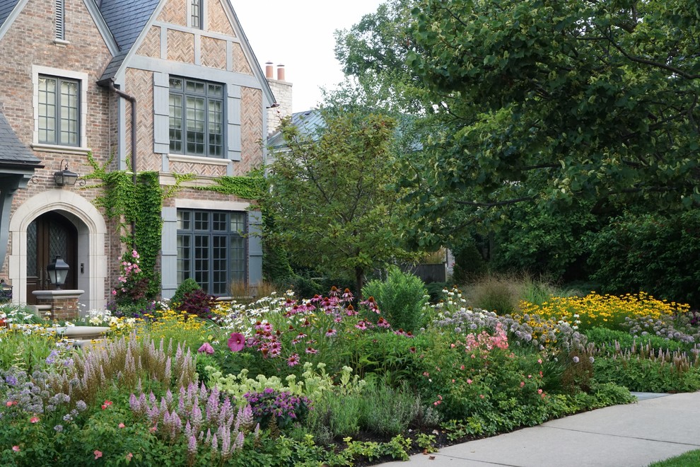 This is an example of a large traditional front yard partial sun formal garden with a garden path and concrete pavers.