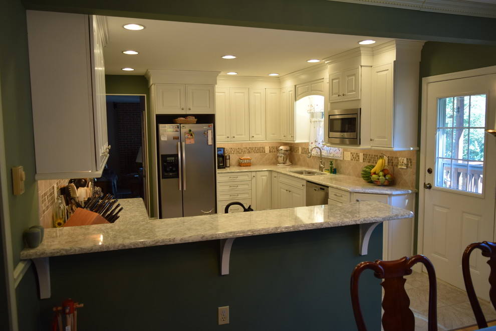 Inspiration for a transitional l-shaped ceramic tile kitchen remodel with a double-bowl sink, raised-panel cabinets, white cabinets, quartz countertops, beige backsplash, ceramic backsplash, stainless steel appliances and no island