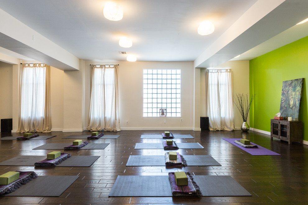 This is an example of a large contemporary home yoga studio in New York with green walls and dark hardwood floors.