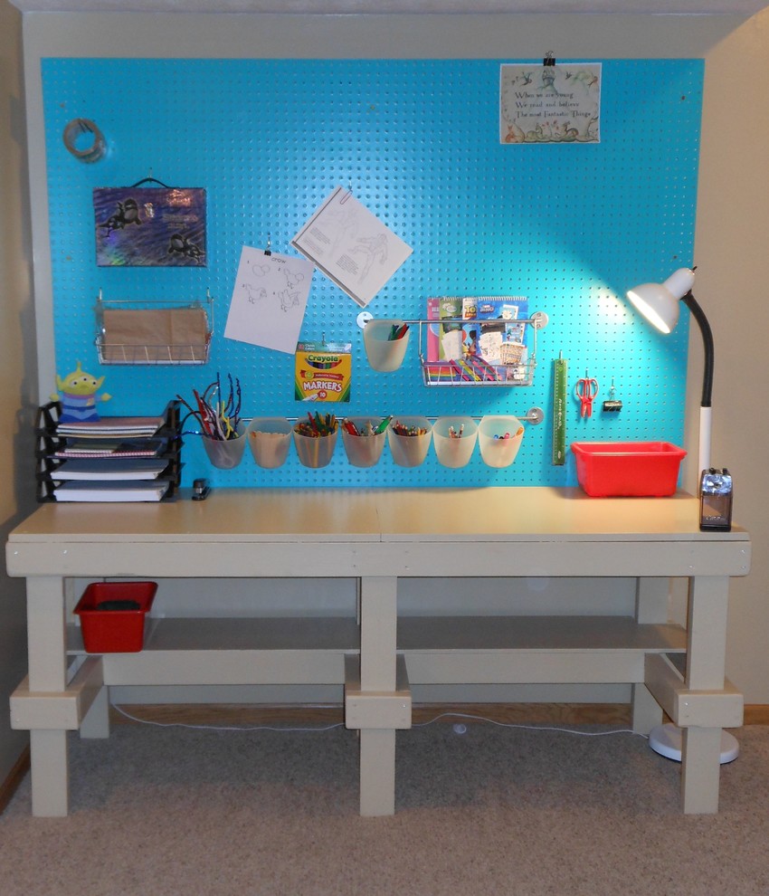 This is an example of a small industrial gender-neutral kids' playroom in Omaha with beige walls.