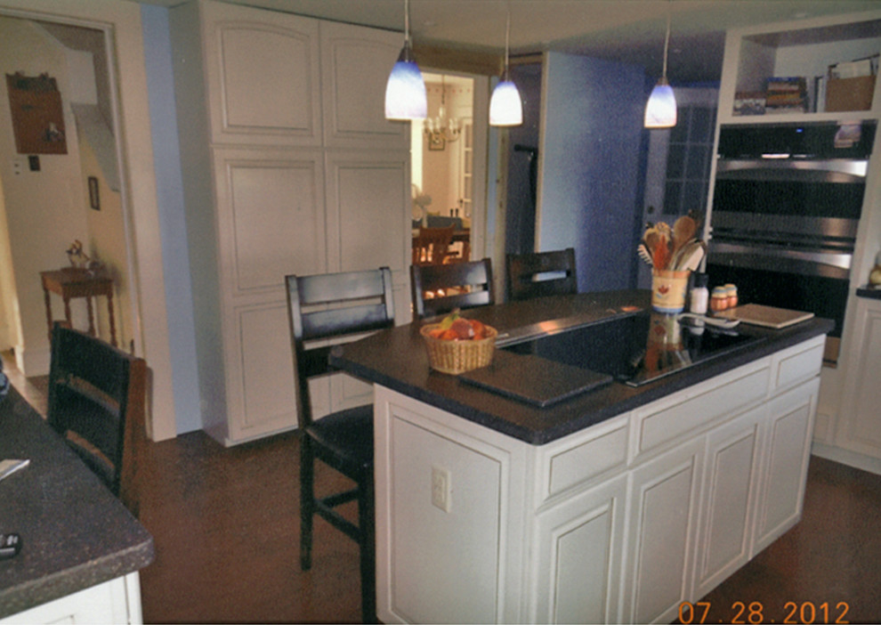 Example of a mid-sized transitional l-shaped medium tone wood floor and brown floor eat-in kitchen design with an undermount sink, raised-panel cabinets, white cabinets, quartz countertops, multicolored backsplash, stainless steel appliances, an island and multicolored countertops