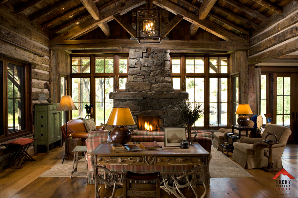 Inspiration for a mid-sized country open concept living room in Other with beige walls, light hardwood floors, a two-sided fireplace and a stone fireplace surround.