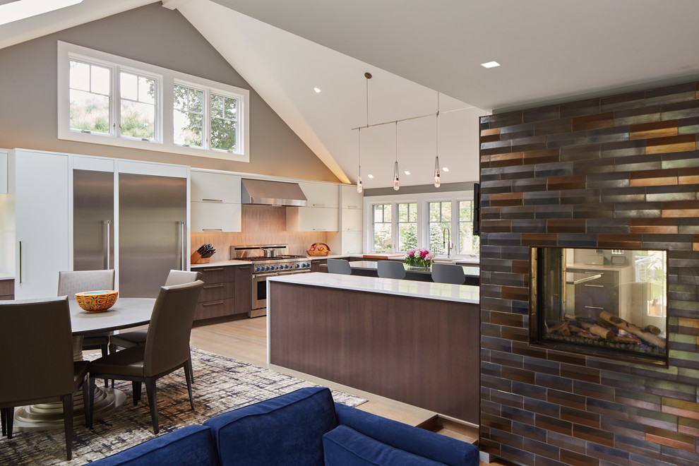 Photo of an expansive contemporary l-shaped eat-in kitchen in Boston with a farmhouse sink, light hardwood floors and multiple islands.