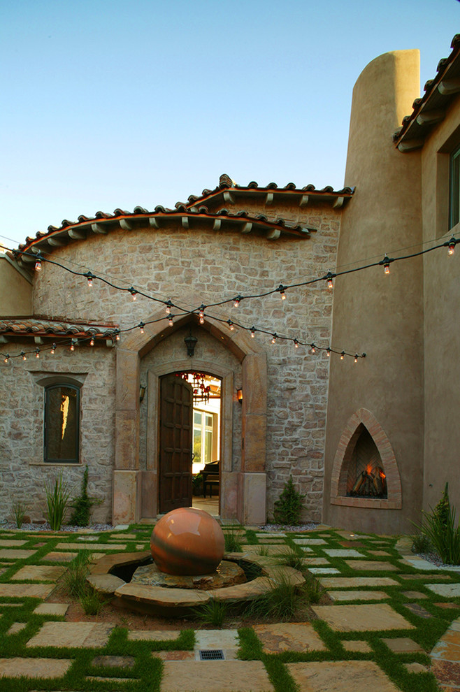 Inspiration for an expansive mediterranean courtyard partial sun xeriscape for spring in Phoenix with a water feature.