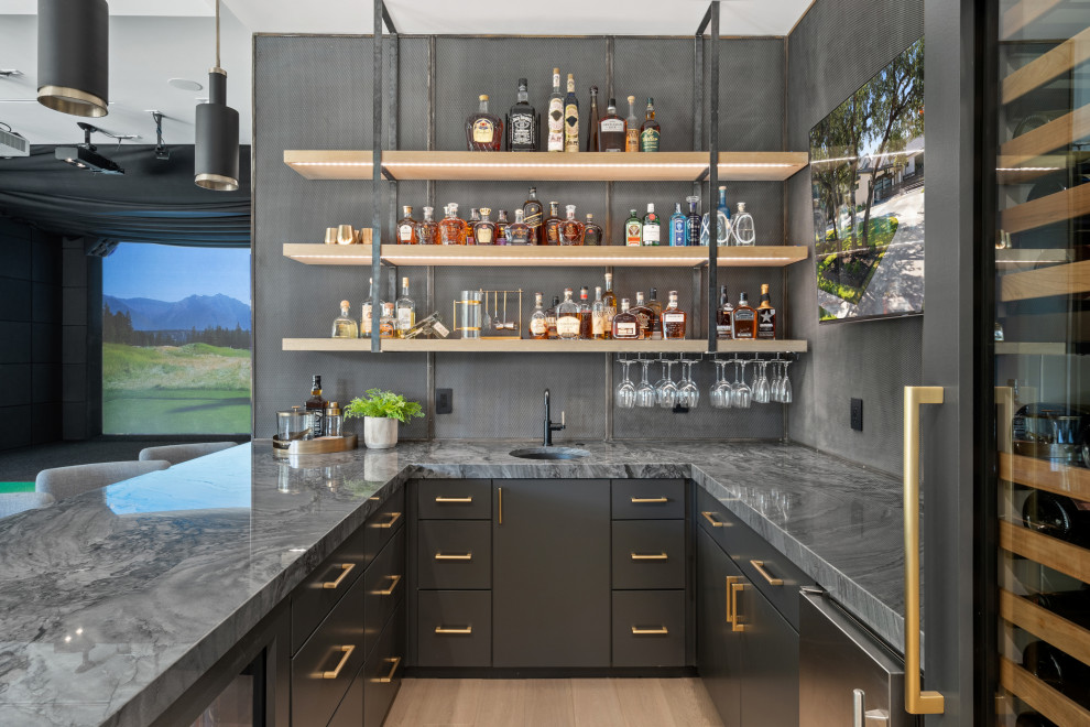 Contemporary u-shaped seated home bar in Austin with light hardwood floors.