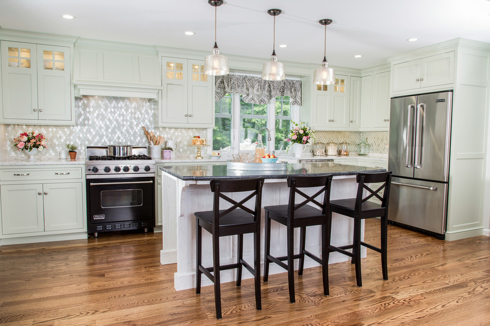 Inspiration for a mid-sized traditional u-shaped eat-in kitchen in Bridgeport with a farmhouse sink, shaker cabinets, green cabinets, granite benchtops, metallic splashback, mosaic tile splashback, stainless steel appliances, medium hardwood floors, with island and brown floor.