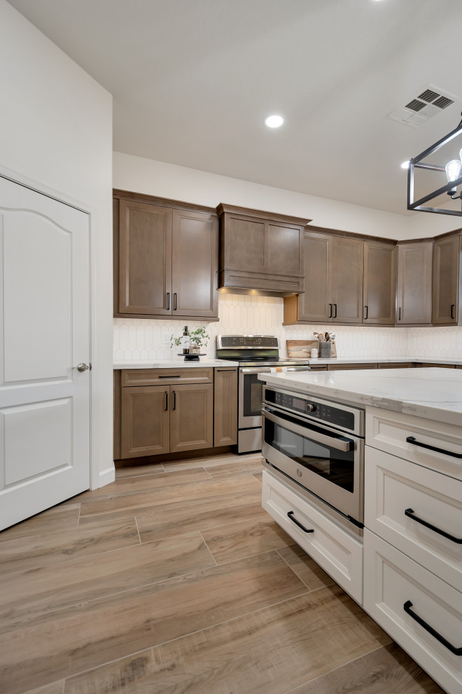 Example of a mid-sized transitional u-shaped ceramic tile and brown floor eat-in kitchen design in Phoenix with beaded inset cabinets, brown cabinets, quartzite countertops, white backsplash, ceramic backsplash, an island and white countertops