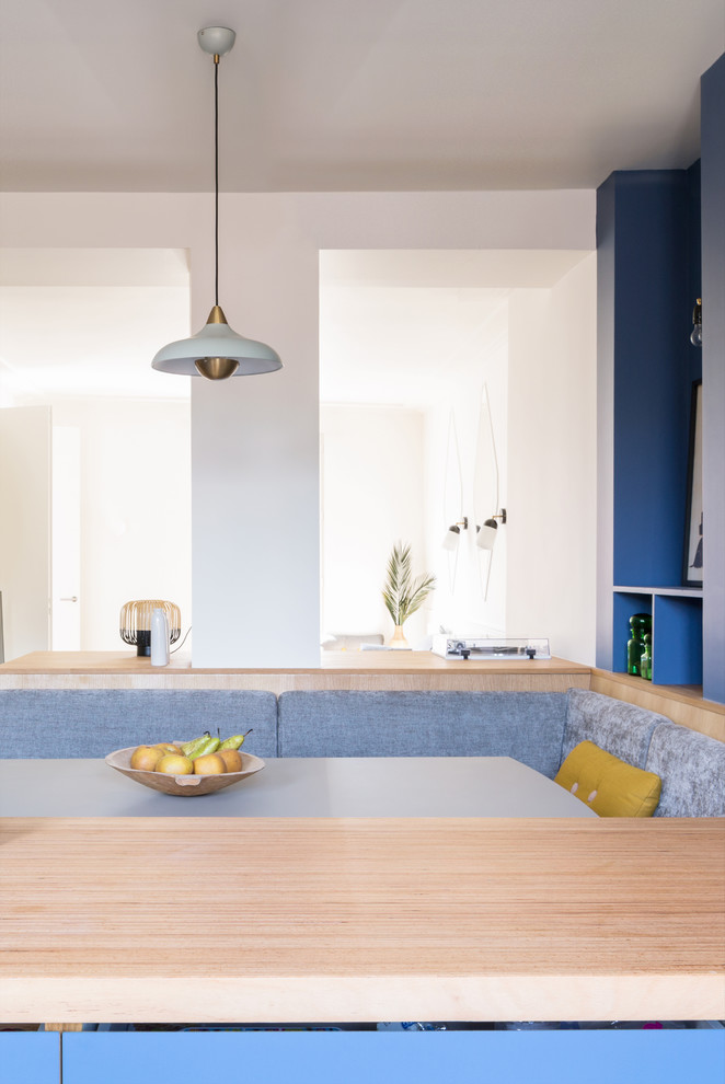 Photo of a mid-sized contemporary single-wall open plan kitchen in Paris with a single-bowl sink, flat-panel cabinets, blue cabinets, wood benchtops, metallic splashback, timber splashback, coloured appliances, ceramic floors, with island, turquoise floor and beige benchtop.