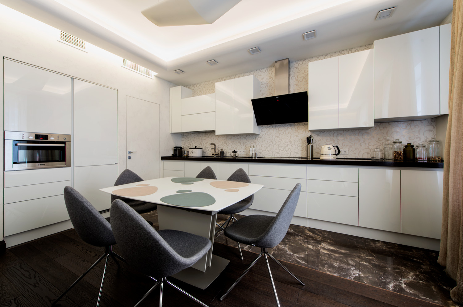 Лаконичная кухня с белыми лаковыми фасадами и встроенными высокими модулями