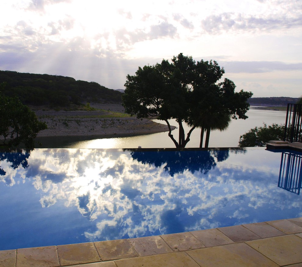 Inspiration for a mid-sized transitional backyard stone and rectangular infinity pool remodel in Orange County