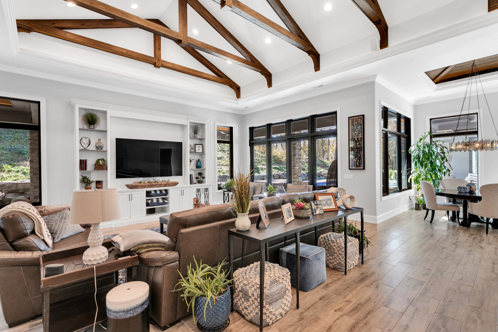 This is an example of an expansive modern open plan games room in Other with a game room, grey walls, ceramic flooring, no fireplace, a built-in media unit, grey floors and exposed beams.